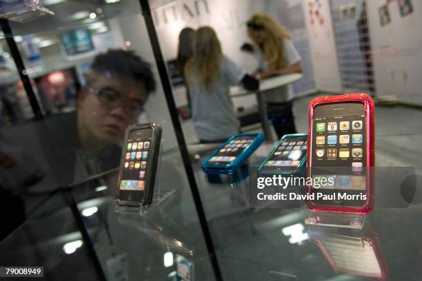 Man looks over a case of iPhones at the 2008 Macworld conference and expo at the Moscone Center January 15, 2008 in San Francisco, California. The...