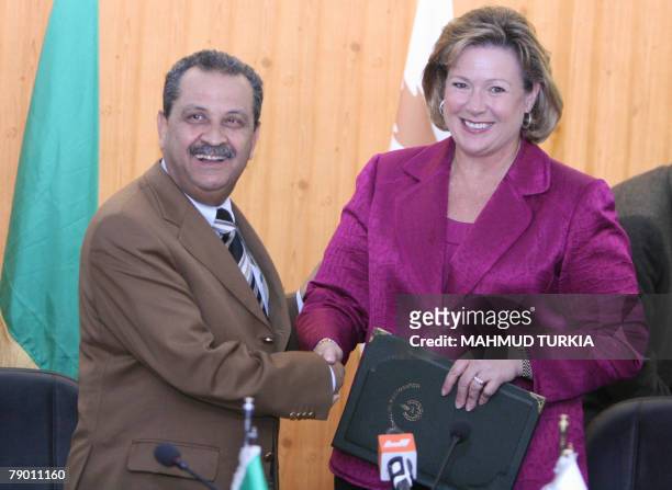 Linda Cook, executive director of the Anglo-Dutch energy giant Shell, and Libyan Oil Minister Shukri Ghanem shake hands after signing 15 January 2008...