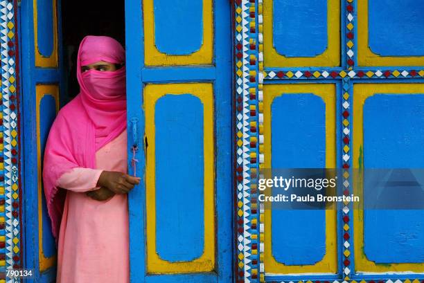 Heanefa looks out from her houseboat, colorfully painted because it is hired for wedding parties, June 20, 2002 on Lake Dal in Srinagar, the summer...