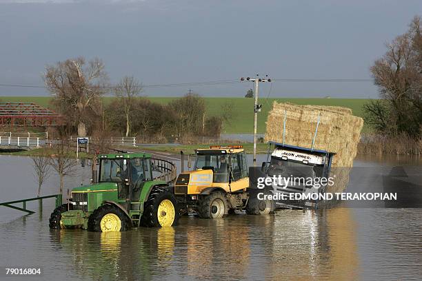 Two tractors tow a truck near the Huntingdon Race Course and car park submerged by flood waters 16 January 2008 in the village of Brampton following...