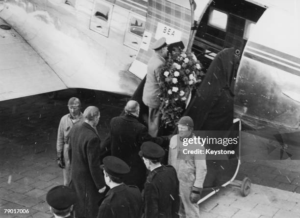 Wreath is carried aboard the aeroplane transporting the body of Manchester United player Duncan Edwards from Munich to manchester, 22nd February...