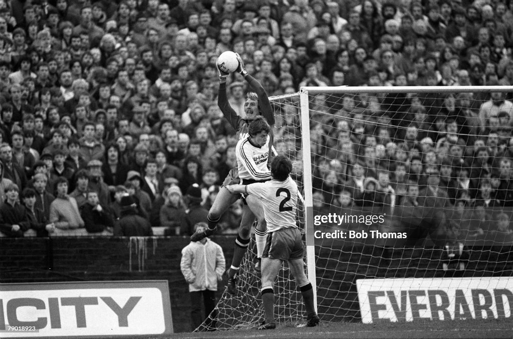 Football. Division One. 4th December 1982. Watford 0 v Manchester United 1. Watford goalkeeper Steve Sherwood catches the ball under pressure from United's Arnold Muhren as Pat Rice (2) looks on.