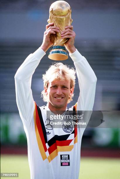 World Cup, Italy, West Germany's Andreas Brehme, holds aloft the trophy at a photocall following their victory over Argentina in Rome