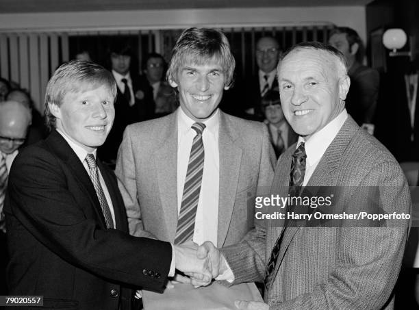Liverpool footballer Sammy Lee receives a man of the match award from former Liverpool manager Bill Shankly as captain Kenny Dalglish joins them at...
