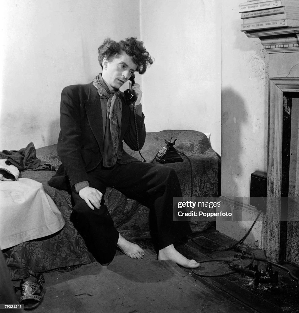 October 1948. English author, actor and artist Quentin Crisp in his scruffy Chelsea flat.