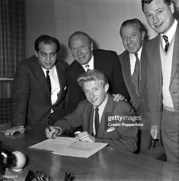 Football, 15th July 1962, Manchester, England, Denis Law signs for Manchester United watched by Italian "Agent" Gigi Peronace, Manager Matt Busby,...