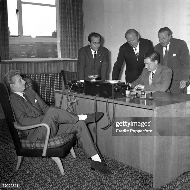 Football, 15th July 1962, Manchester, England, Denis Law relaxes as he watches Manchester United Secretary Les Olive complete his new contract...