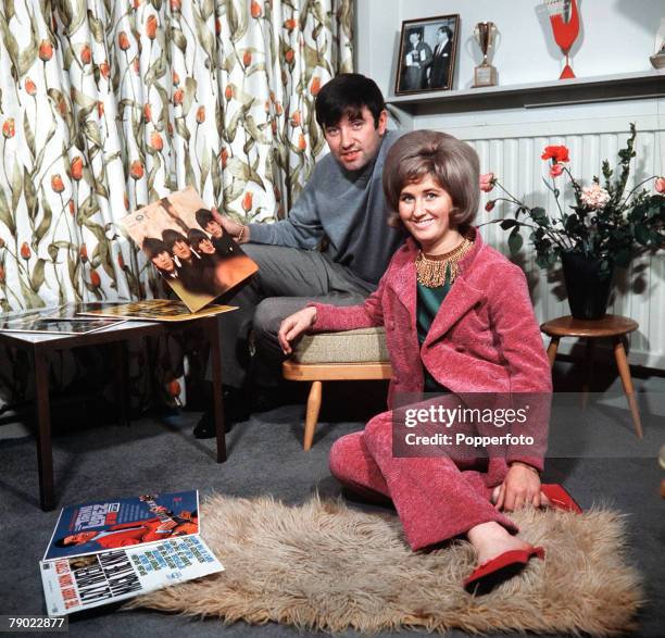 Liverpool, England, Comedian and entertainer Jimmy Tarbuck is pictured at home with his wife Pauline holding the "Beatles For Sale" album in his...