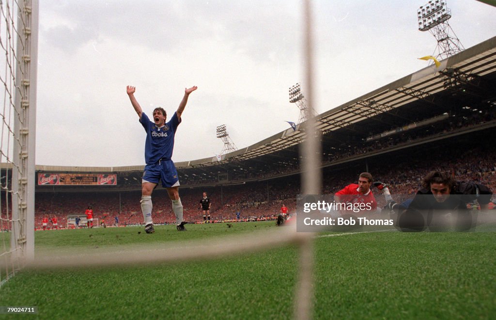 Football. 1997 FA Cup Final. Wembley. 17th May, 1997. Chelsea 2 v Middlesbrough 0. A view from inside the goal showing Chelsea's Mark Hughes celebrating the second goal scored by Eddie Newton as Middlesbrough goalkeeper Ben Roberts looks on.