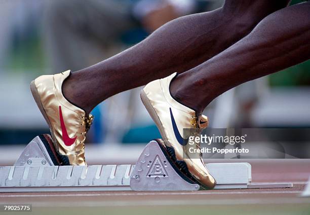Close up view of the Nike gold running shoes of American track athlete Michael Johnson competing during the heats before finishing in first place in...