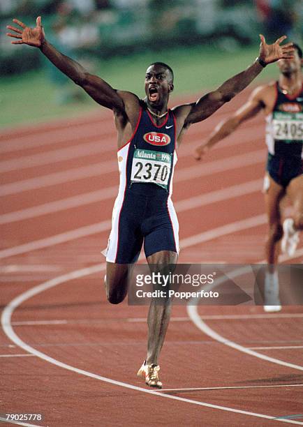 American track athlete Michael Johnson celebrates after finishing in first place in a new world record time to win the gold medal in the final of the...