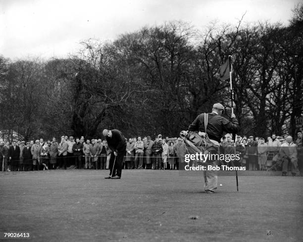 Closed Championships Little Aston, England, Legendary British golfer Peter Alliss is seen putting on the green, as his caddy holds the flag, watched...