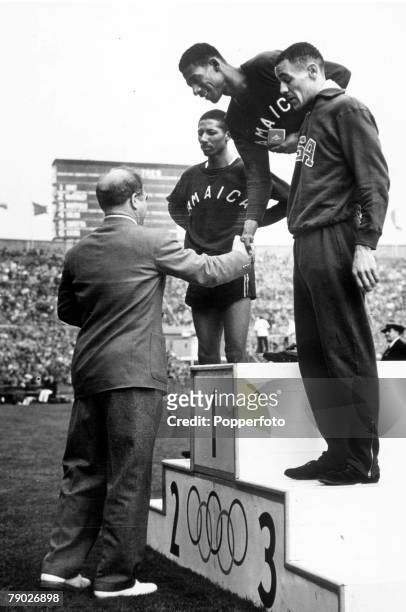 Olympic Games, London, England, Men's 400 Metres, Jamaica's Arthur Wint receives the gold medal on the podium after the race with Jamaica's Herb...