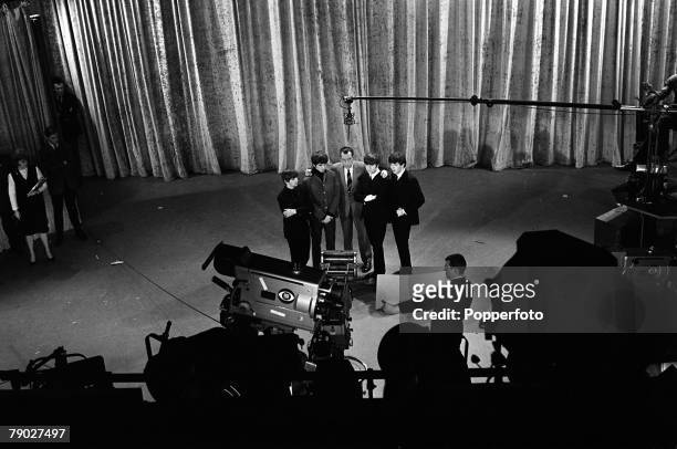 Elevated view of American television talk show host Ed Sullivan as he stands, with the members of British rock group the Beatles, on the set of his...