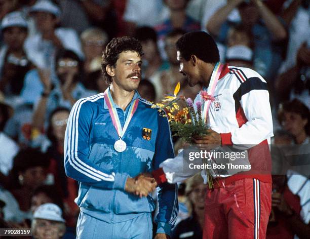 Daley Thompson of Great Britain , gold medal winner in the men's decathlon competition, shakes hands with silver medal winner Jurgen Hingsen of West...