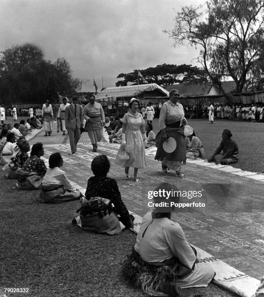 Royal Tour of Tonga, December Her Majesty Queen Elizabeth II accompanied by Queen Salote walks over a carpet of Tapa cloth to the feast house as...