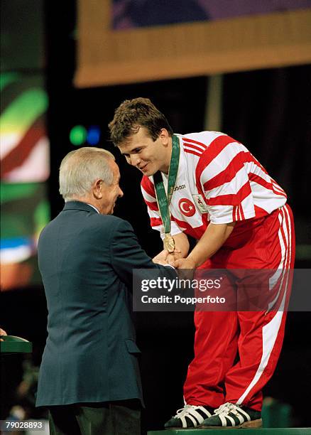 Turkish weightlifter Naim Suleymanoglu pictured being presented with the gold medal on the medal podium by International Olympic Committee President...
