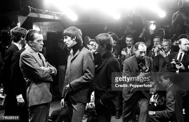 American television show host Ed Sullivan talks with British Rock musicians George Harrison and Ringo Starr, both of the group the Beatles, as...