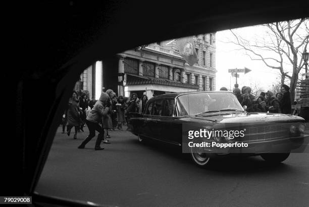 Beatles fans run after a car carrying members of the British Rock group the Beatles outside the Plaza Hotel, New York, New York, February 9, 1964....
