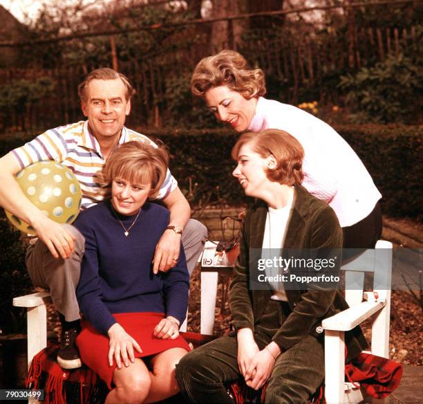 Picture of the British actor Ian Carmichael sitting outside with his family