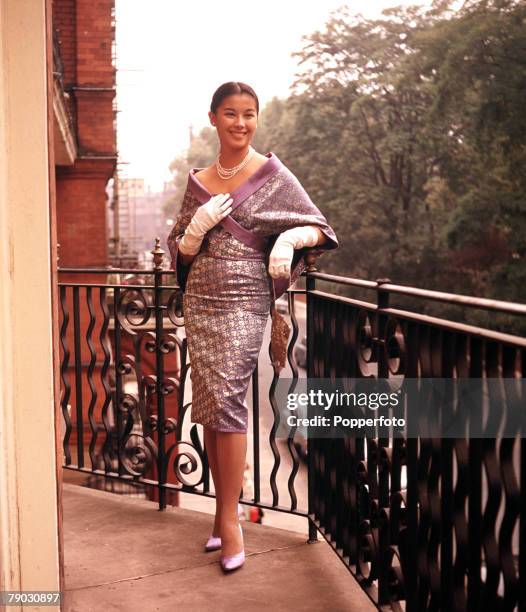 Circa 1960+s, A picture of the Eurasian actress France Nuyen modeling an attractive cocktail dress and cape in her London apartment