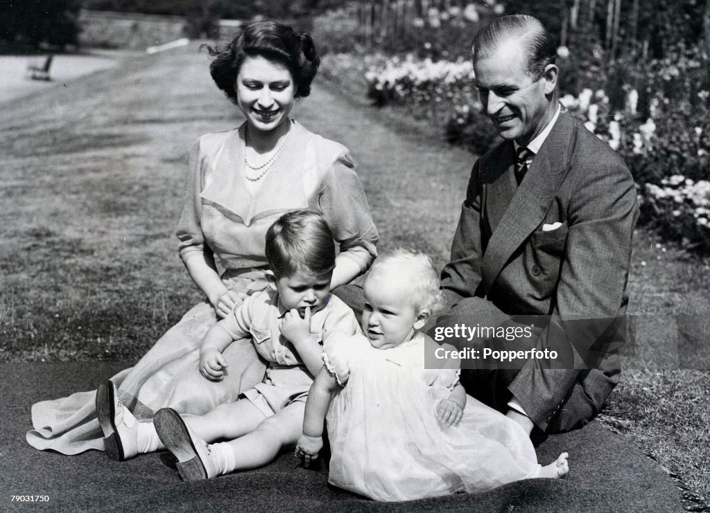 Royalty. 9th August 1951. A portrait of the Royal Family, Princess Elizabeth II and the Duke of Edinburgh with their young children Prince Charles and Princess Anne, sitting on the lawn in the gardens of Clarence house, the Royal+s London residence.