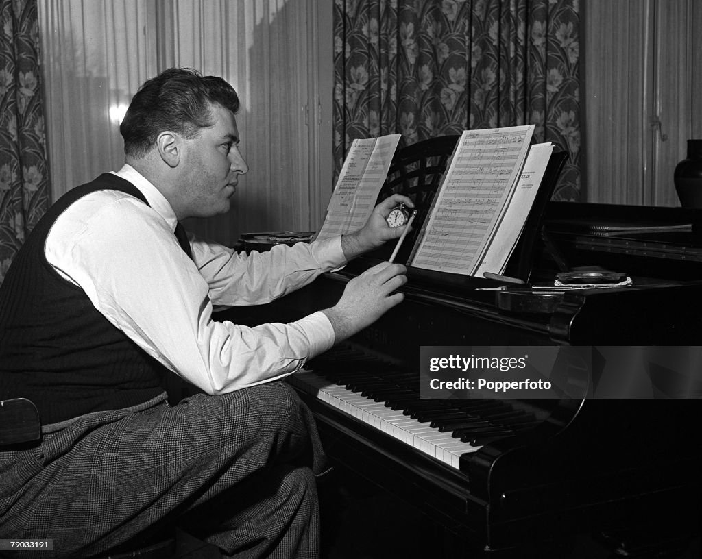 London, England. 1949. Canadian music composer and orchestra leader Robert Joseph Farnon is pictured playing the piano at his Earls Court home.