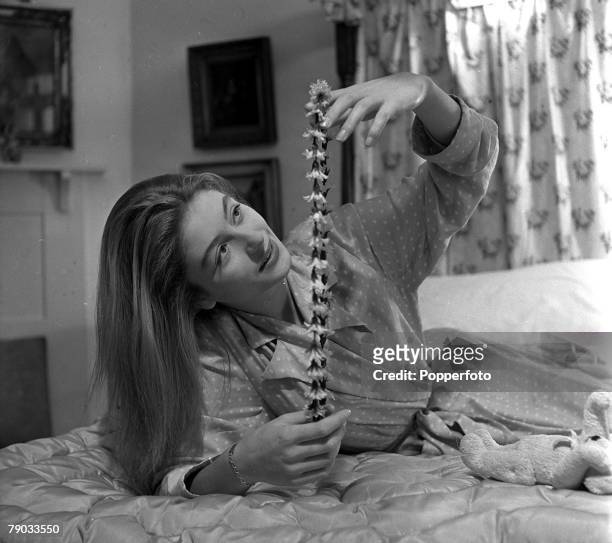 Denham Village, England 17 year old French actress Anouk Aimee who is in England to act in the film "Golden Salamander" is pictured with a garland of...