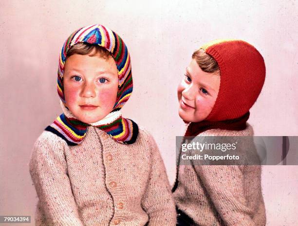 Fashion, A picture of a two young boys sitting together in a studio wearing fashionable matching cardigans and colourful woollen balaclavas whilst...