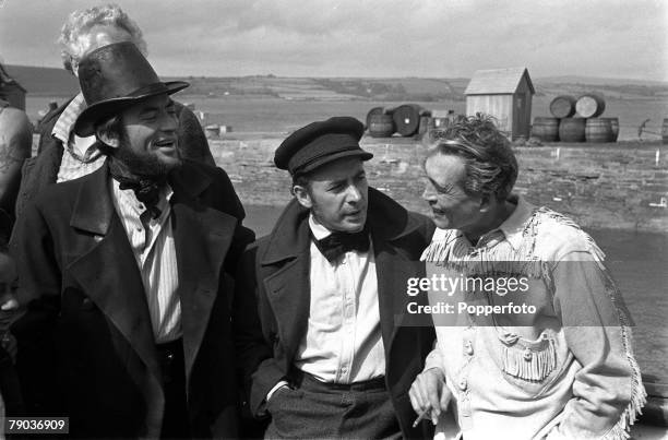 Cinema Actors L-R: Gregory Peck and Leo Genn talk with legendary American director John Huston on the set of the film "Moby Dick"