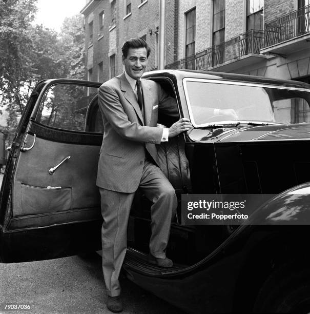 Cinema, England British actor Guy Rolfe is pictured next to his Rolls Royce car