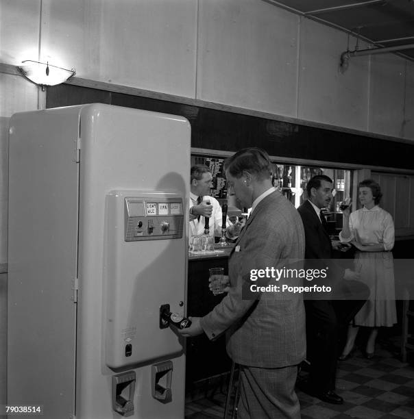 Chislehurst, Kent, England An automatic barmaid machine is pictured at the Tiger's Head public house, as a customer purchases a bottle of beer