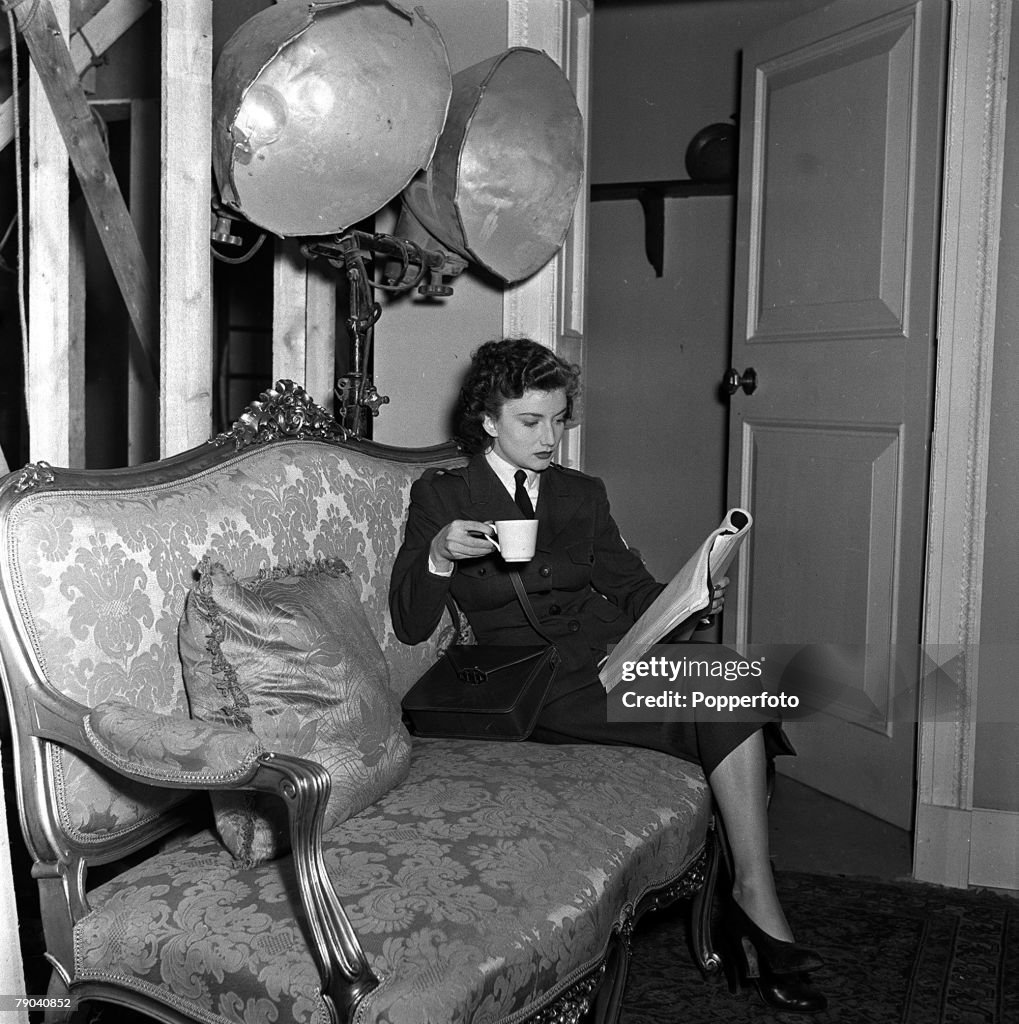 England. 1950. Kenyan born British actress Zena Marshall is pictured drinking a cup of tea as she learns her lines on the set of the film "Hell is Sold Out".