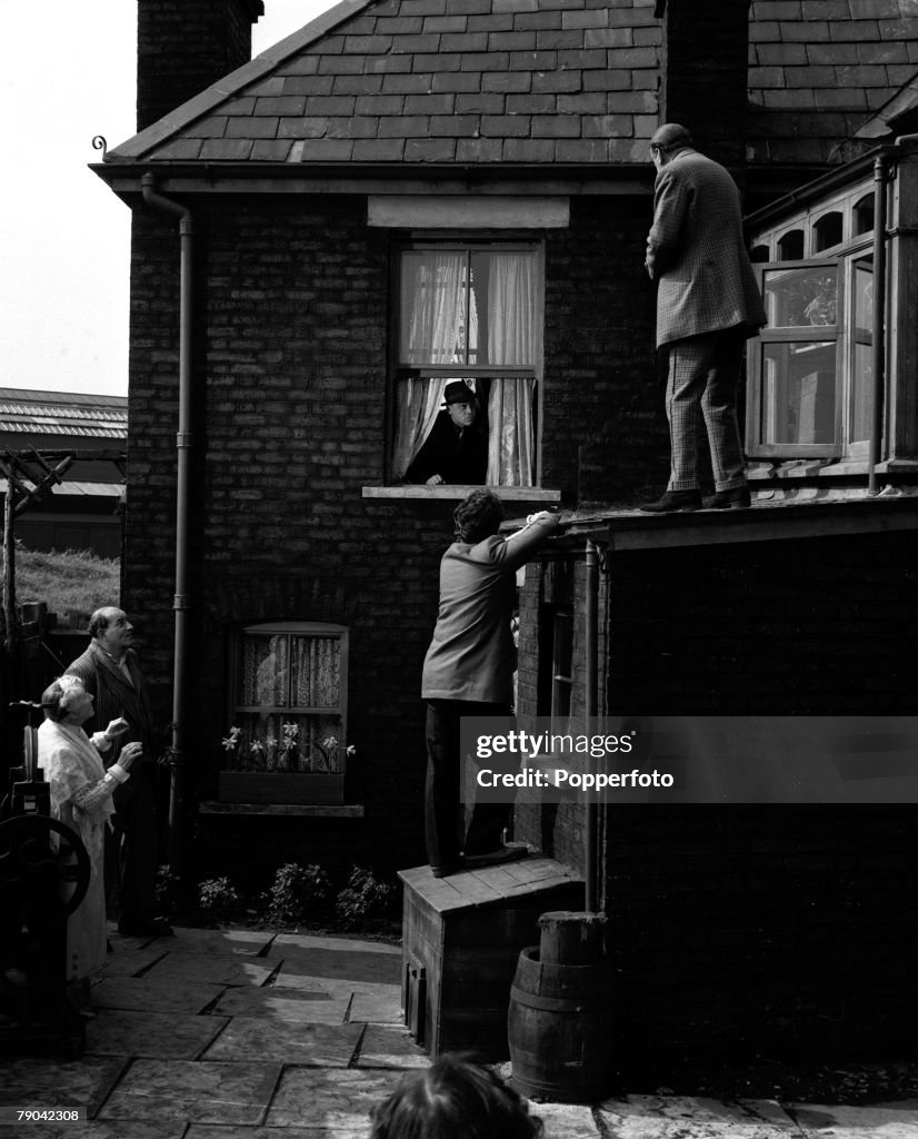 London, England. 1955. A scene from the Ealing comedy film "The Ladykillers". Pictured are L-R: Katie Johnson, Danny Green, Herbert Lom (in window), Peter Sellers, and Cecil Parker.