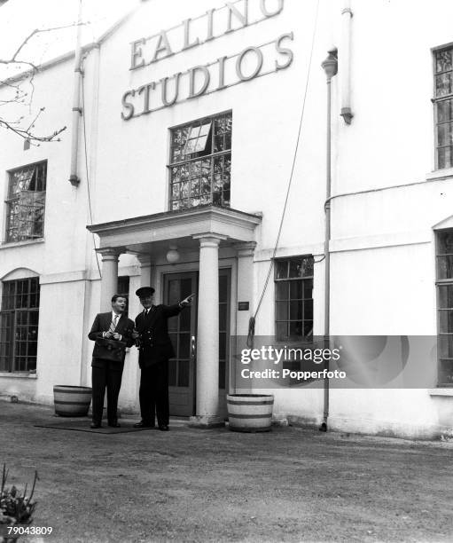 London, England British actor and comedian Benny Hill is pictured with the commissionaire during his first day on a film set at the Ealing studios