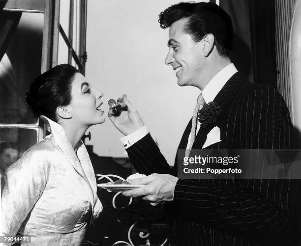 London, England, 25th May 1952, British Actor Maxwell Reed and actress Joan Collins enjoy strawberries and cream at their wedding reception