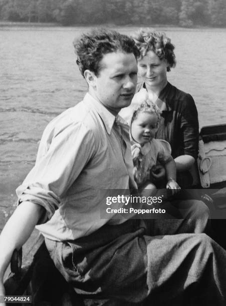 Literature, Welsh poet Dylan Thomas enjoys a boat trip with his wife Caitlin and baby daughter Aeronwy on the River Taff, Laugharne, South Wales,...