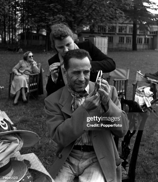 American film star Humphrey Bogart is pictured being made-up on the set of the film "The African Queen"