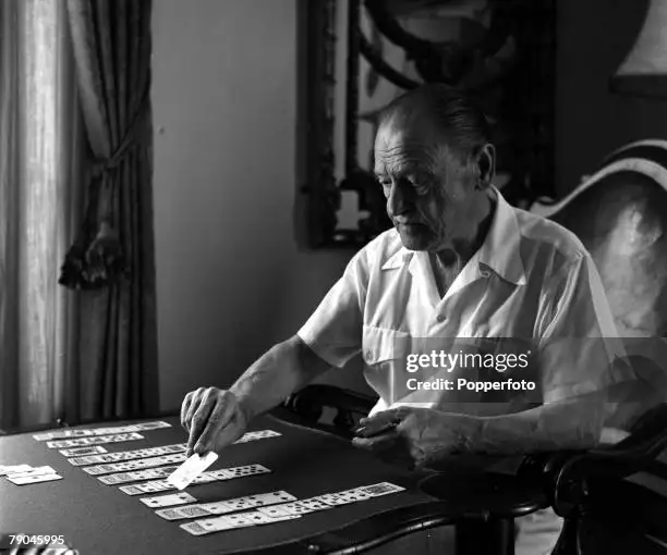 English author Somerset Maugham, playing a game of patience at his Villa La Mauresque in 1954.