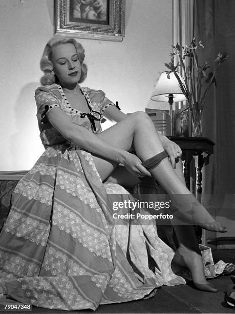 England, A picture of British actress Patti Morgan demonstrating how to put on a pair of nylon stockings