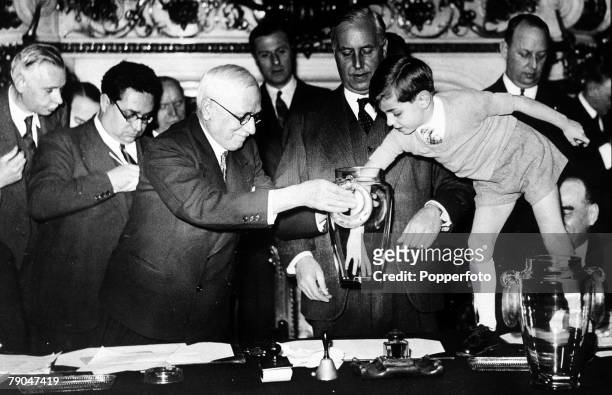World Cup Finals Paris, France, FIFA president Jules Rimet is assisted by a young boy in making the draw for the World Cup