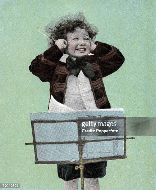 Classic Collection, Page 12 Hand tinted photograph showing a child in jacket and cravat with his hands over his ears, standing in front of a music...