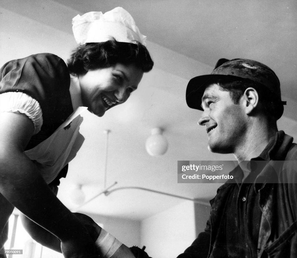 Classic Collection. Page 52. 10388586. Circa 1954. Easington Colliery,' Durham. A smiling nurse tends to an injured coal miners hand at a medical centre.