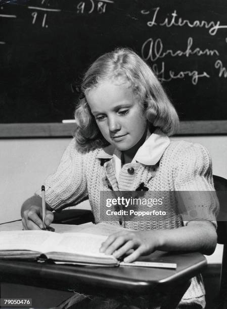 Classic Collection, Page: 33 A studious young girl sitting at her school desk concentrating, writing down her work with a pencil during class