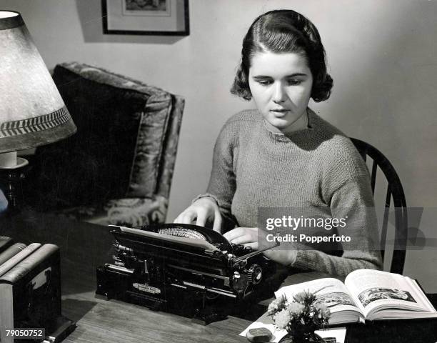 Classic Collection, Page: 38 A studious young school girl sitting at her desk reading from a book, while using a typewriter