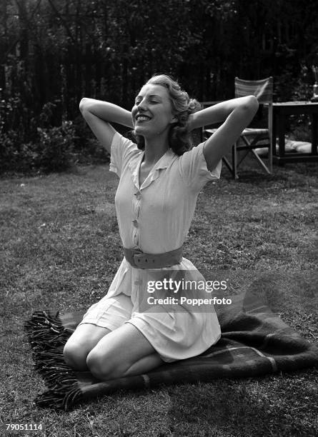 English singer Vera Lynn , known as 'the Forces' Sweetheart', poses for a photo-shoot sitting on a blanket in the garden enjoying a stretch in the...