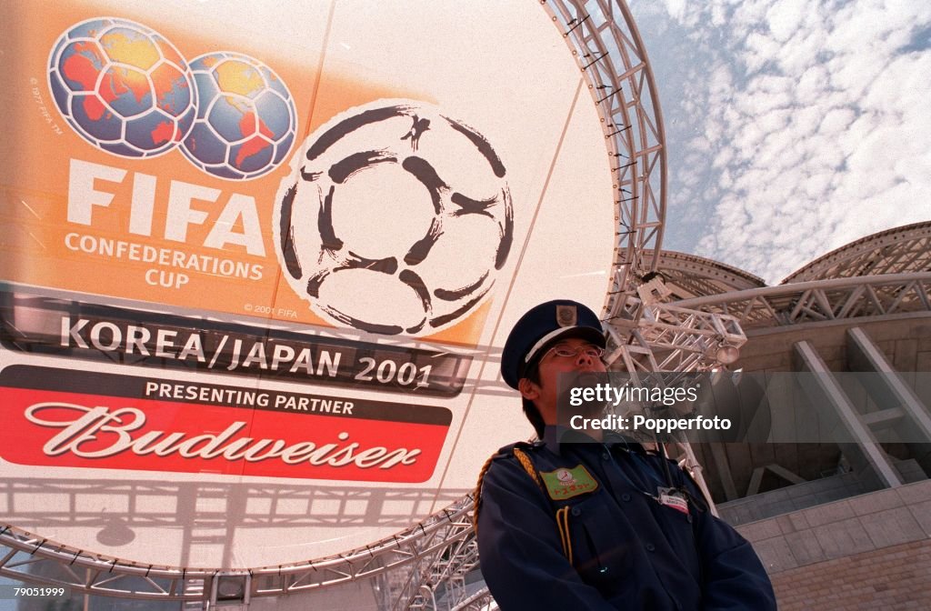 Football. FIFA Confederations Cup. 2nd June 2001. Niigata, Japan. Cameroon 0 v Japan 2. A security guard stands in front of advertising for the 2002 World Cup Finals at the Niigata Stadium.