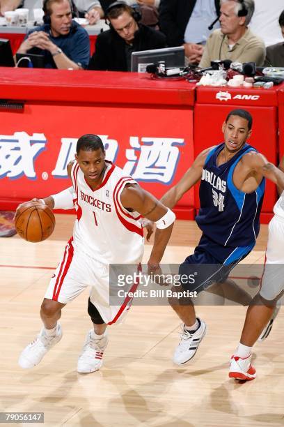 Tracy McGrady of the Houston Rockets drives the ball past Devin Harris of the Dallas Mavericks during the game on December 15, 2007 at the Toyota...