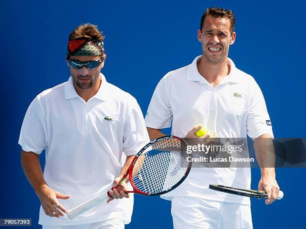 Arnaud Clement of France and Michael Llodra of France talk tactics during their doubles match against Sanchai Ratiwatana and Sonchat Ratiwatana of...