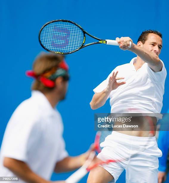 Michael Llodra of France plays a forehand during his doubles match with Arnaud Clement of France against Sanchai Ratiwatana and Sonchat Ratiwatana of...